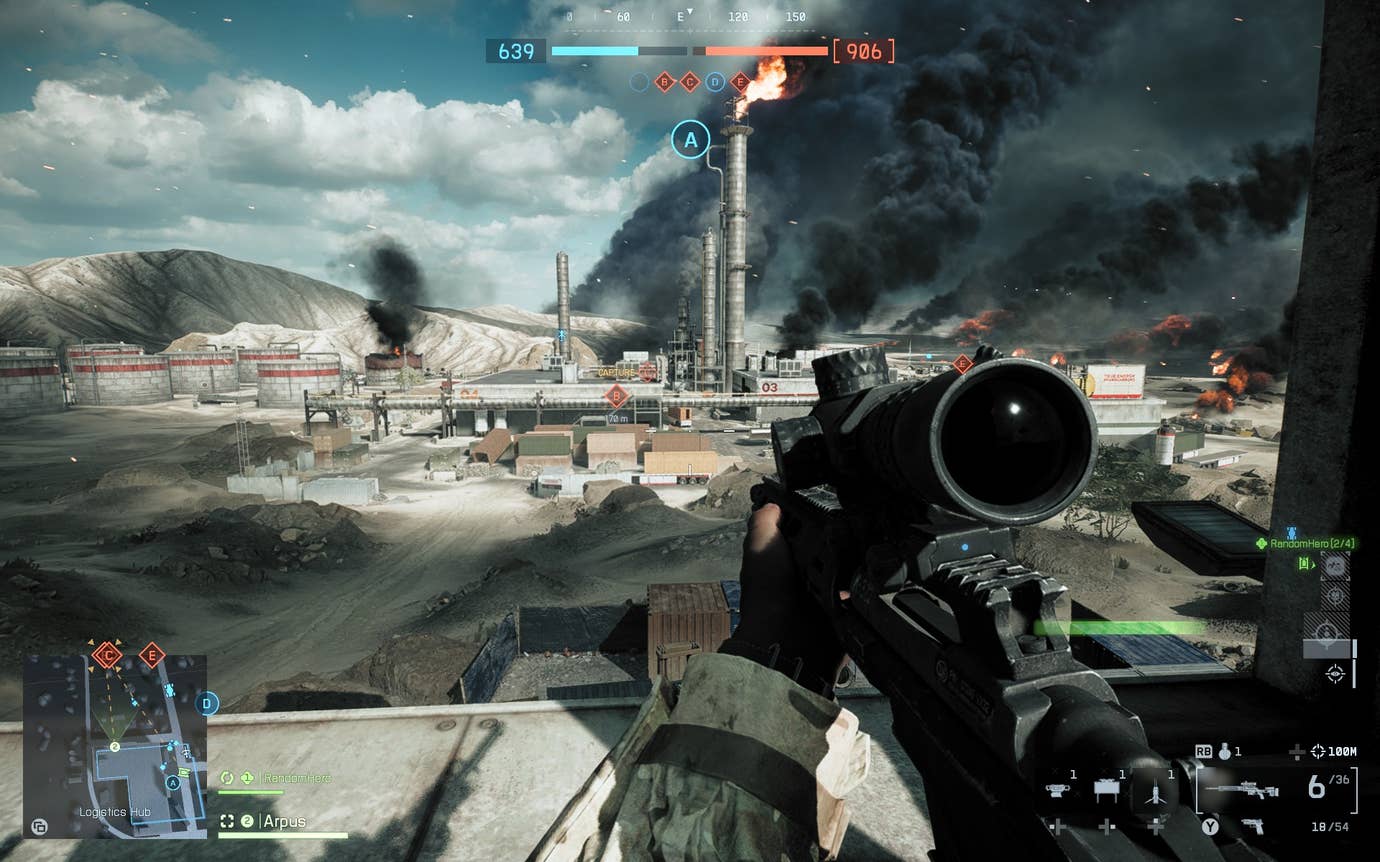 A view of a desert oil drilling facility from a rooftop in Battlefield 6. The player is holding a scoped rifle and there is flame emerging from a distant chimneystack.